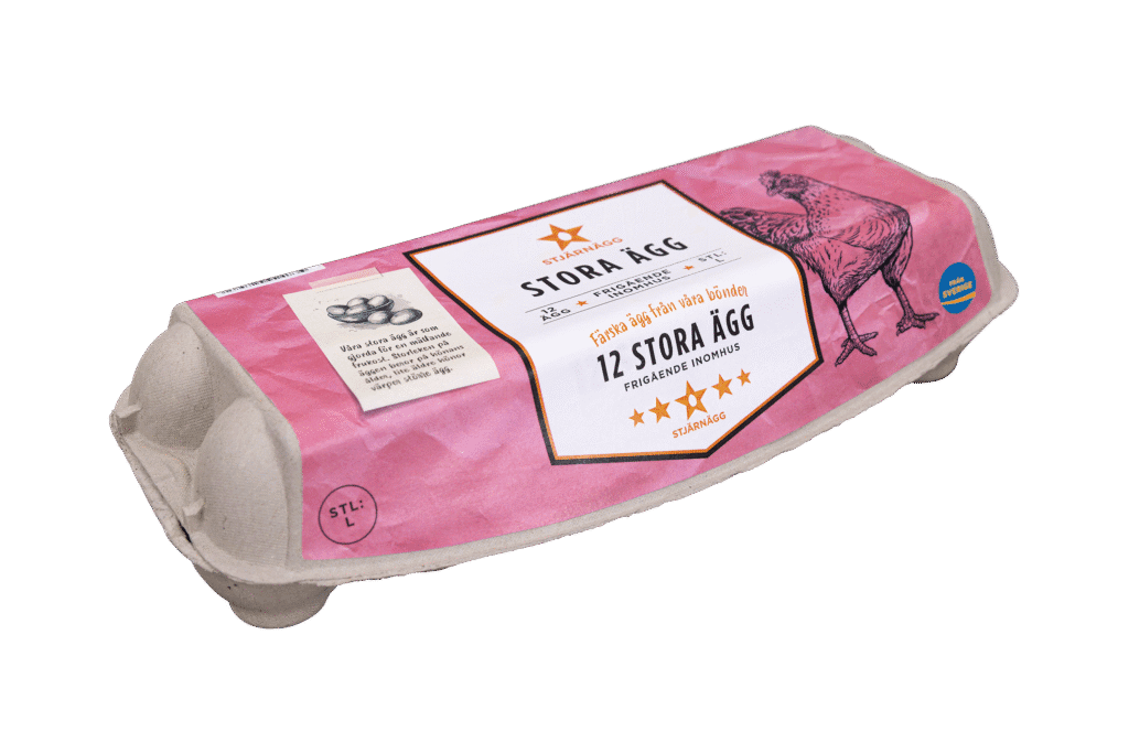 En kartong med 12 stora ägg med en rosa etikett med en illustration av en höna och svensk text, bland annat Stora Ägg och 12 stora ägg. Kartongen är tillverkad av återvunnet material.