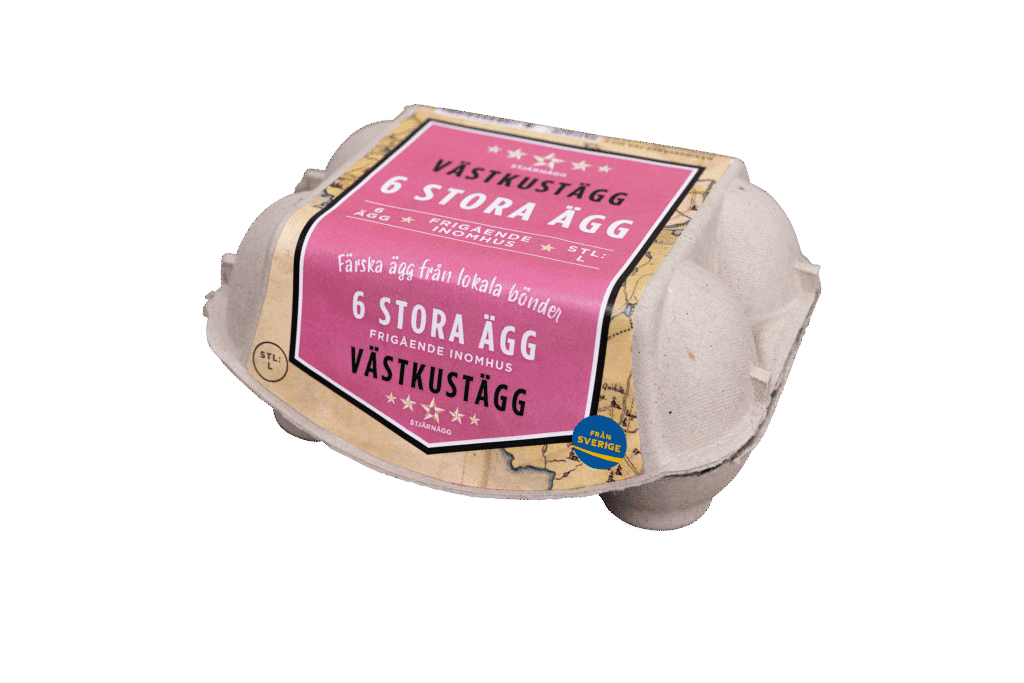 En kartong med sex stora ägg märkta Västkustägg 6 Stora Ägg på svenska, med en rosa och beige etikett som visar att äggen är färska och kommer från lokala gårdar i Sverige.
