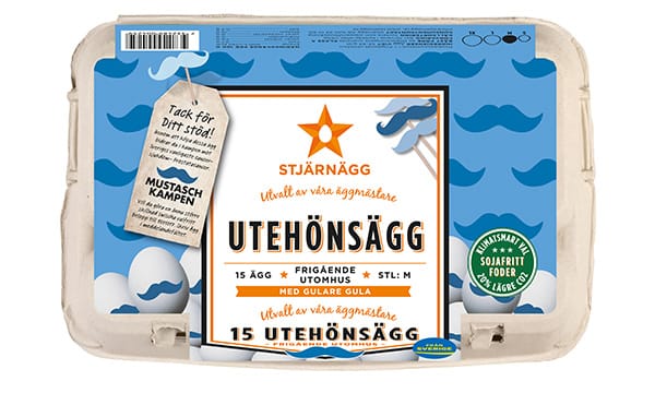 En kartong med ägg av märket Stjärnägg märkta Utehönsägg innehållande 15 ägg från frigående höns, med blå och orange design och text på svenska, och en tagg som stöder Mustasch Kampen fäst på förpackningen.
