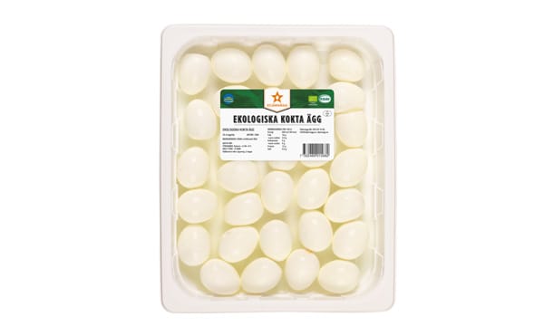 En plastbehållare fylld med skalade hårdkokta ägg, arrangerade i rader. På den grönvita etiketten ovanpå står det Ekologiska KOKTA ÄGG, vilket betyder ekologiska kokta ägg.