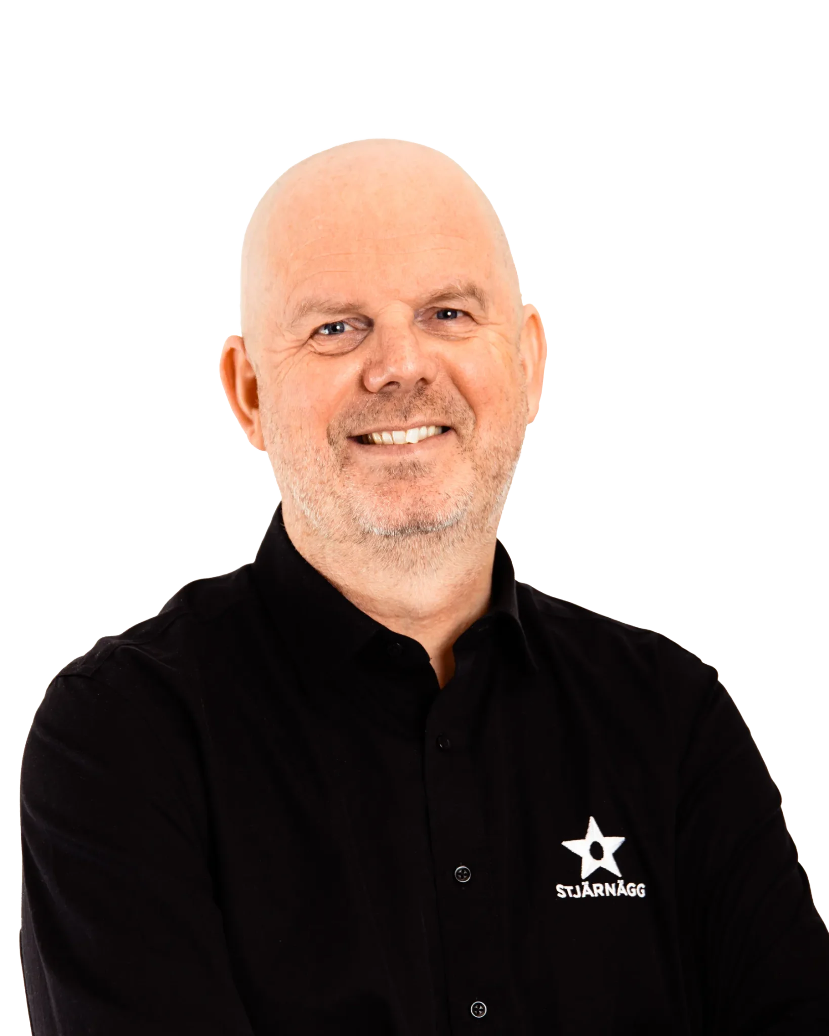 En leende skallig man med skägg, klädd i en svart skjorta med vit stjärna och ordet STJÄRNÄGG, står självsäkert med armarna löst korsade mot en enfärgad bakgrund.